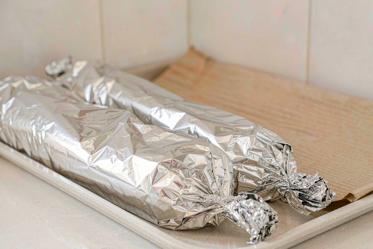 Foil wrapped freezer breakfast burritos arranged on a tray