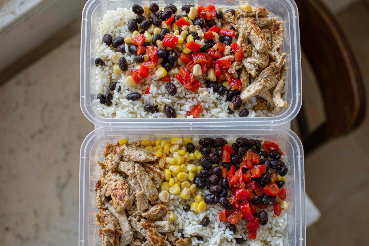 Five mason jar salads layered with dressing chickpeas vegetables and greens on top